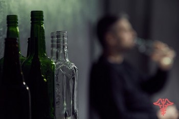 Бутылки на фоне алкоголика